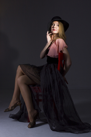 Portrait of a young woman in a hat on a black backgroundの写真素材