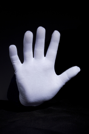 Hand in glove with white cloth gesturingの写真素材