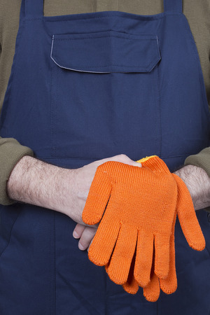 Man in working clothes with gloves. Isolated on a white background.の写真素材