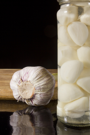 Marinated and fresh garlic with a grater on a dark backgroundの写真素材