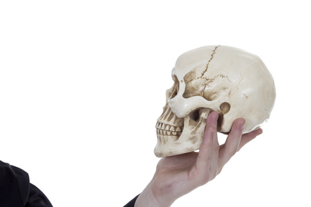 Skull in a male hand on a white backgroundの写真素材