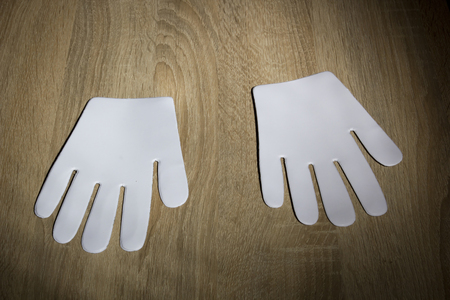 White glove forms on a wooden tableの写真素材