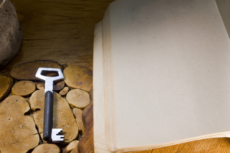 Old book and key on a wooden kitchen tableの写真素材