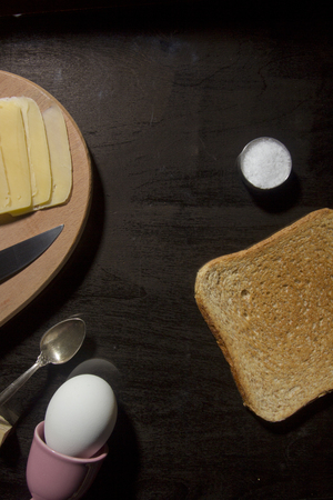 Breakfast option with egg on a black wooden boardの写真素材