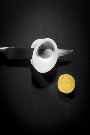 Cut with a knife boiled chicken egg on a black backgroundの写真素材
