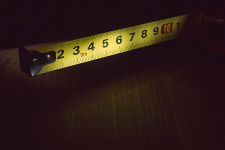 Part of the measuring tape on a wooden tableの写真素材