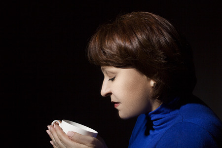 Portrait of a woman with a cup of fragrant coffeeの写真素材