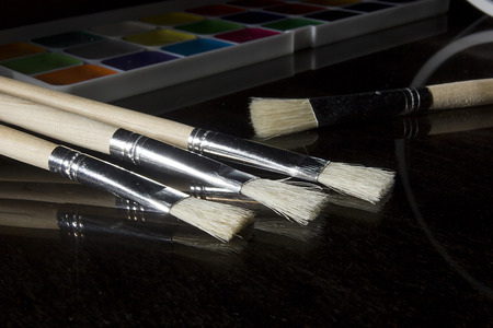 Wooden painting brushes close-up on a black background