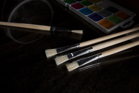Wooden painting brushes close-up on a black backgroundの写真素材
