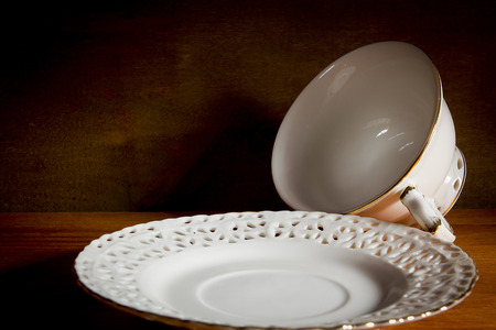 White tea cups and a saucer on a wooden tableの写真素材