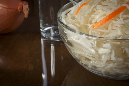 Bowl of sauerkraut on a wooden reflective surfaceの写真素材