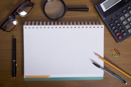 Open notebook and office accessories on the desktopの写真素材