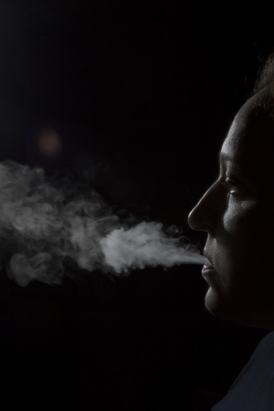 Silhouette of a smoking woman on a black backgroundの写真素材
