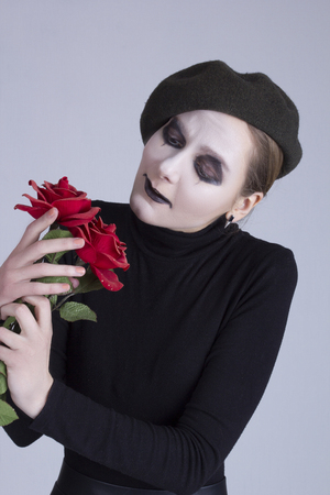 Mime girl with red roses on a gray backgroundの写真素材