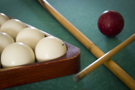 Old billiard balls on a table with green cloth