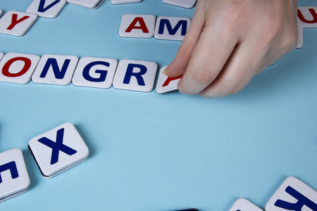 Female hands spread letters on a blue background