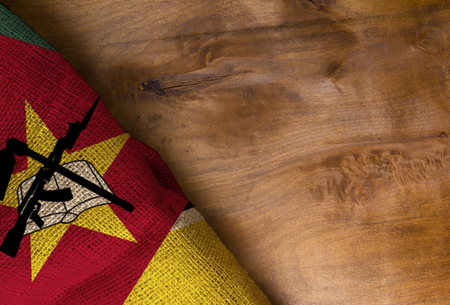 Flag of Mozambique from rough fabric on a wooden surfaceの写真素材