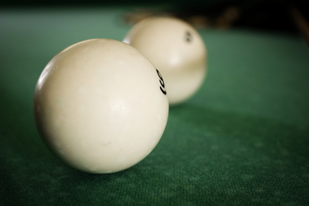 Old billiard balls on a table with green clothの写真素材