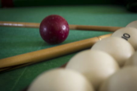 Old billiard balls on a table with green clothの写真素材