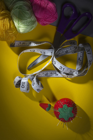 Tools and accessories for sewing on a yellow backgroundの写真素材