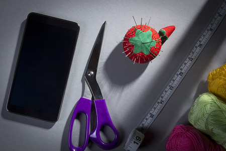 Tools and accessories for sewing on a gray background