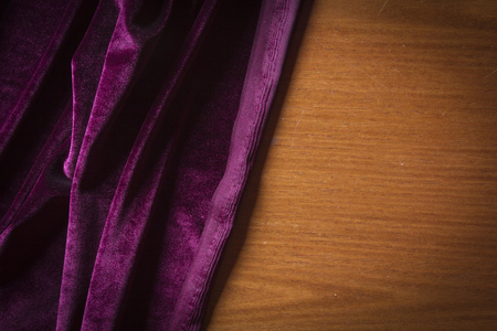 Purple velor fabric on a wooden surfaceの写真素材