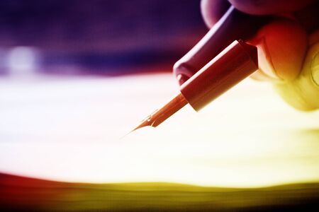 Closeup of hand with fountain pen over blank paper