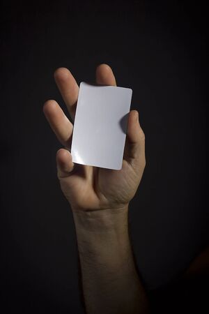 Male hand with a white cardboard cardの写真素材