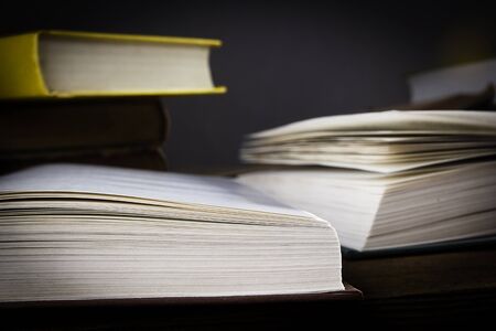 Piles of books on a table on a black background