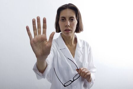 Doctor woman with raised open palm on white backgroundの写真素材