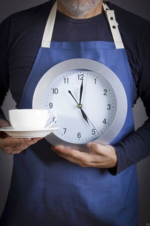 Five o'clock tea party concept. Man with a clock and a cup of tea