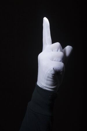 The index finger of a female hand in a white glove is raised upの写真素材