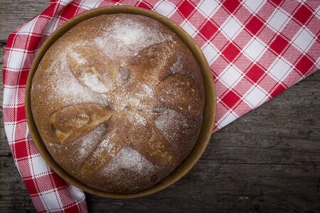 Plate with a loaf of bread on a table of old woodの写真素材