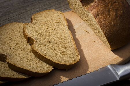Sliced bread on a cutting board on a table of old wood
