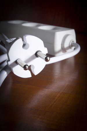 White extension cord on a wooden table