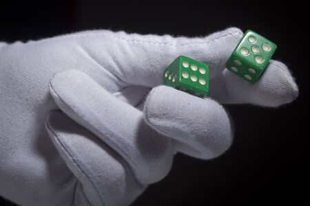 Hand in a white glove with green diceの写真素材