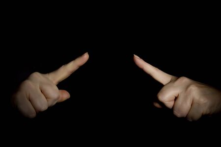 Hands with index fingers on a black backgroundの写真素材
