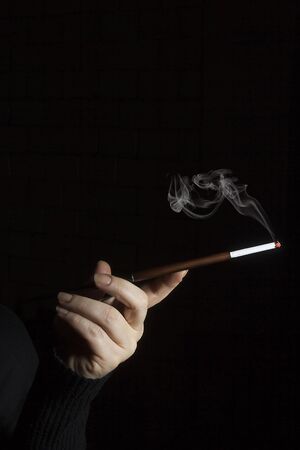 Female hand with mouthpiece on a black backgroundの写真素材