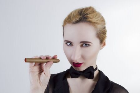 Young woman with butterfly and cigar on a white backgroundの写真素材