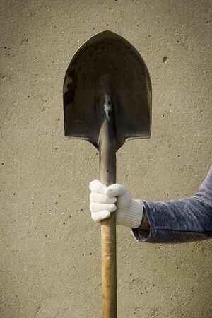Male hand in work glove with a shovel