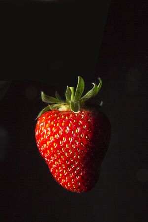 Ripe red strawberries on a black backgroundの写真素材