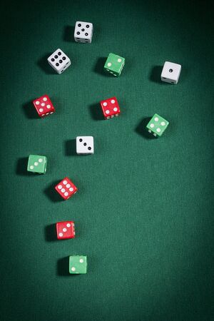 Multi-colored dice on a playing table with green clothの写真素材
