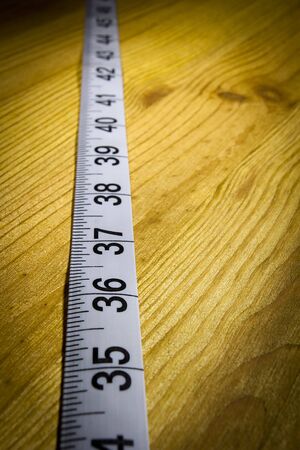 White tailor meter on a wooden tableの写真素材