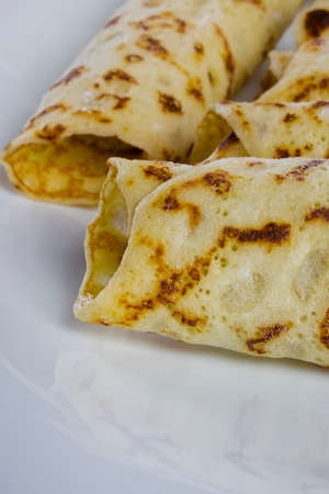 Pancakes with sweet cream on a white plate