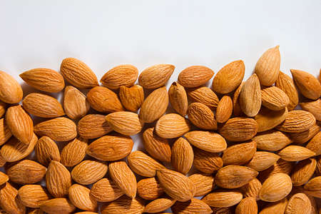 Lots of almond nuts on white backgroundの写真素材