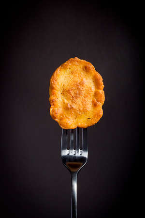 Corn pancakes on a fork on a black backgroundの写真素材