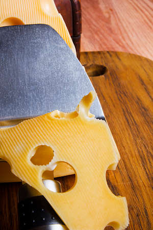 Cheese and cheese knife on wooden cutting boardの写真素材