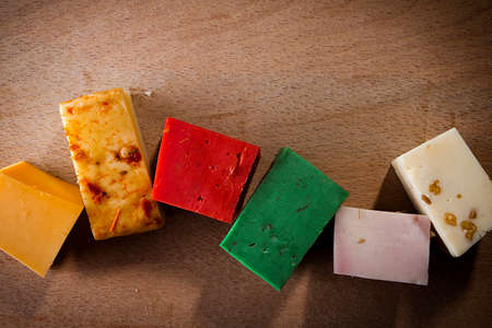 Pieces of colorful cheeses on a wooden backgroundの写真素材