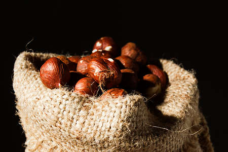 Unpeeled hazelnuts in a bag close upの写真素材