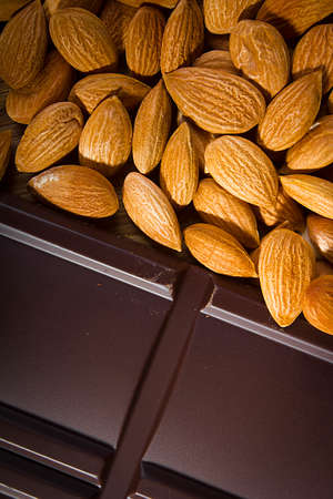 Dried almond nuts and dark chocolate bar